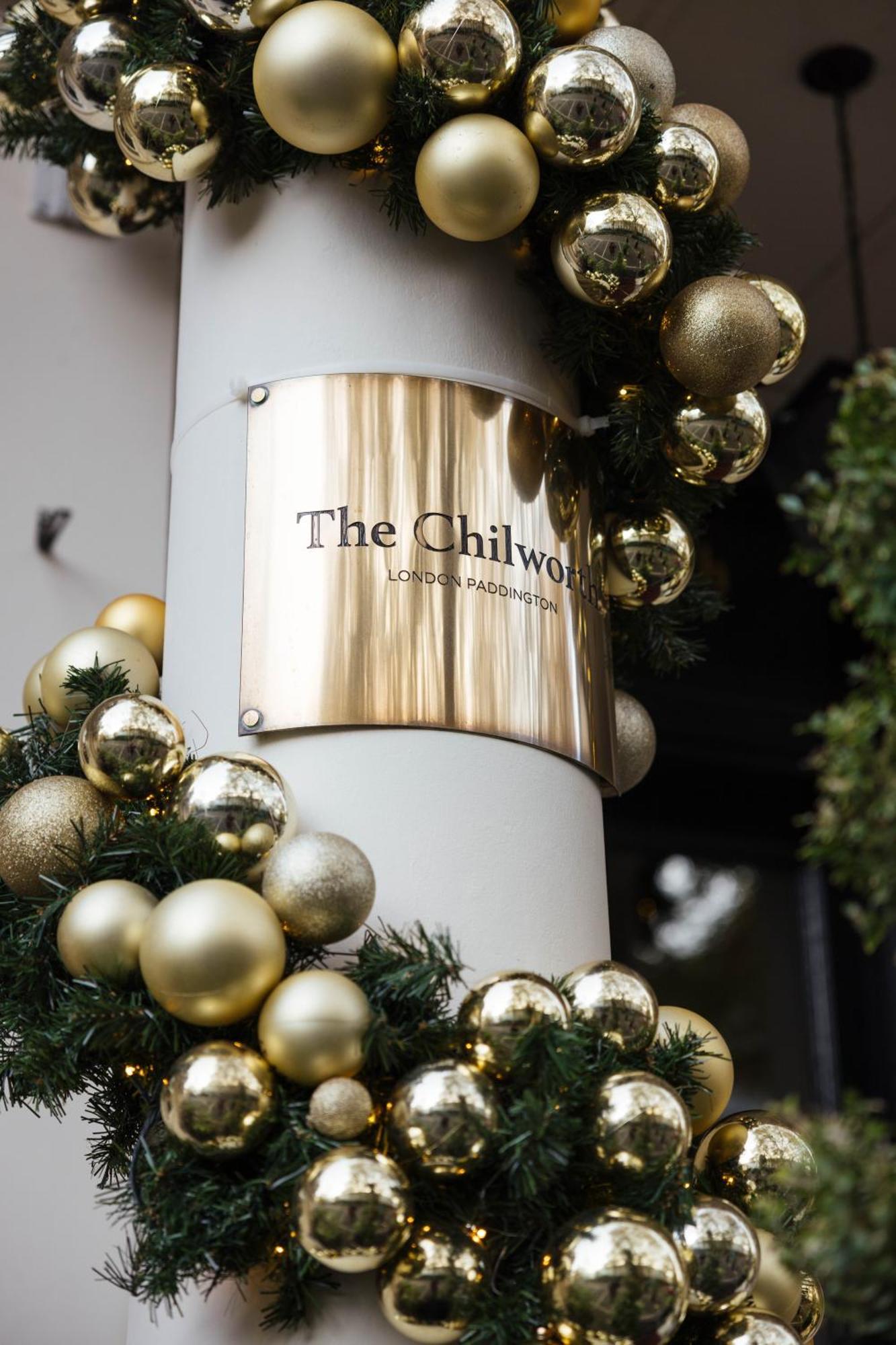 Montcalm Chilworth Townhouse, Paddington Hotel Londres Exterior foto The photo shows a decorative sign mounted on a pillar, indicating "The Chilworth," with the subtitle "London Paddington." The sign is made of a shiny brass material. Surrounding the sign are festive decorations, including green garlands and various g