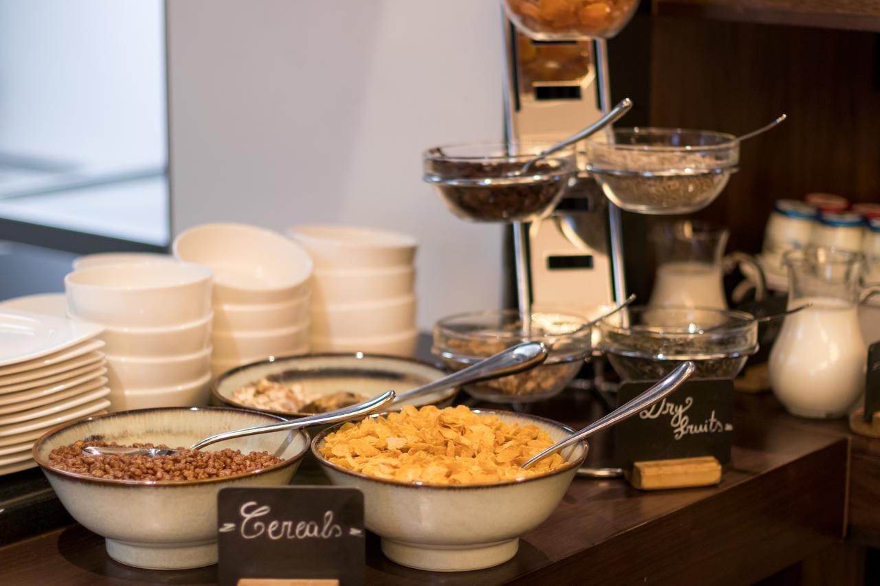 Montcalm Chilworth Townhouse, Paddington Hotel Londres Exterior foto The photo shows a breakfast buffet setup featuring various cereals. There are multiple bowls containing different types of cereals, such as granola and possibly cornflakes. Each bowl has a spoon for serving. In the background, there are white plates 