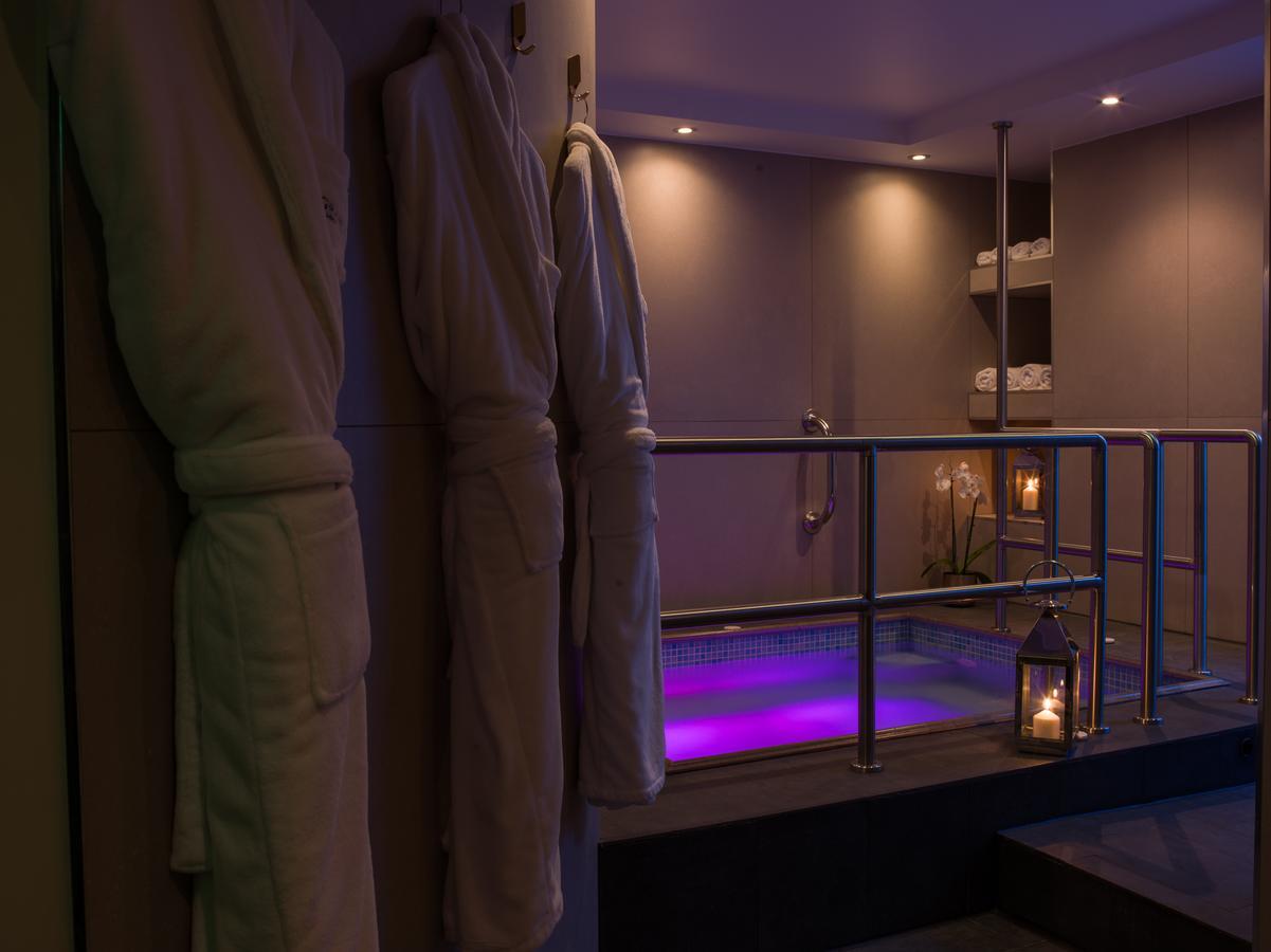 Montcalm Chilworth Townhouse, Paddington Hotel Londres Exterior foto The photo depicts a serene spa setting. On one side, there are several plush bathrobes hanging on a rail, suggesting a relaxing atmosphere. In the background, a hot tub is visible, illuminated with soft purple lighting, enhancing the tranquil vibe. T