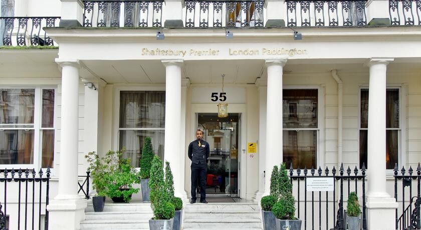 Montcalm Chilworth Townhouse, Paddington Hotel Londres Exterior foto The photo shows the entrance of a building, specifically the front of a hotel or hospitality establishment named "St. Athansbury Premier London Paddington." The entrance features a set of columns and a number "55" displayed prominently. A person is s